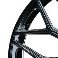 Glossy black car wheel rim, featuring sleek geometric spokes, presented against a plain white background.