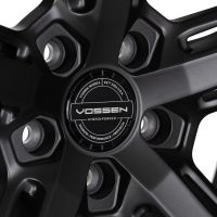 A black alloy wheel showcases a central circular hub with the text: "VOSSEN WHEELS ESTP 2006 U.S.A. VOSSEN HYBRID-FORGED PASSION · PERFORMANCE · PRECISION," set against a sleek, metallic background.
