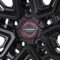 Black alloy wheel with intricate geometric design, featuring a red center cap labeled "VOSSEN HYBRID-FORGED," surrounded by text: "VOSSEN WHEELS EST. 2006 U.S.A. PASSION - PERFORMANCE - PRECISION."