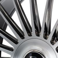 A close-up of a polished, multi-spoke alloy wheel features sleek, metallic spokes radiating from the center, set against a plain background, highlighting its modern design.